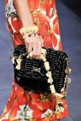 Модная сумка-клатч чёрного цвета из материала крупного плетения, подчёркнутая золотисто-молочной гаммой стилизованной цепочки из коллекции сумок 2013 года от Dolce&Gabbana