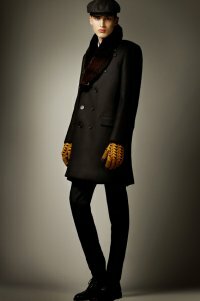 Мужское драповое пальто чёрного цвета двубортного фасона с меховым воротником от Burberry Prorsum в сочетании с брюками чёрного тона, жёлтыми перчатками Burberry Prorsum и чёрными туфлями Burberry Prorsum.