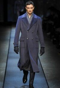 Длинное драповое пальто синего цвета двубортного фасона из новой коллекции Canali в сочетании с шарфом чёрно-серого тона, серыми брюками Canali и туфлями чёрного цвета от Canali.
