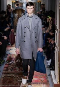 Зимнее драповое пальто для мужчин серого цвета двубортного фасона от Valentino в сочетании с классическими чёрными брюками Valentino и туфлями бело-коричневого оттенка Valentino.