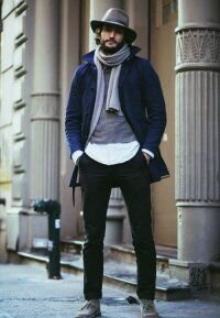 Зимнее мужское пальто королевского синего тона однобортного фасона средней длины в сочетании с шляпой и шарфом серого цвета, свитером асфальтного оттенка, чёрными брюками и ботинками светло-серой расцветки.