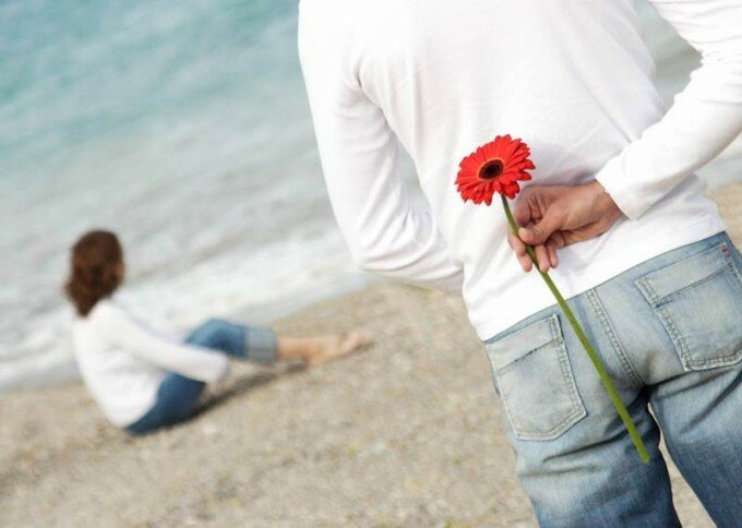 Мужчина дарит женщине цветок. Влюбленный мужчина доверяет той, которую любит 